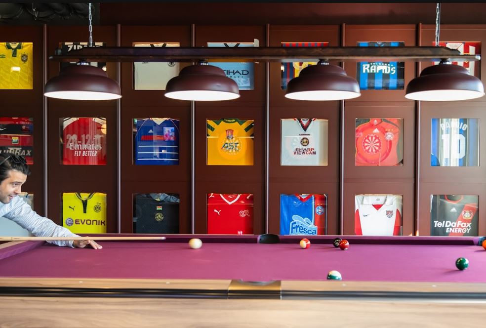 A game of pool at Fat Tony's, surrounded by framed sports jerseys